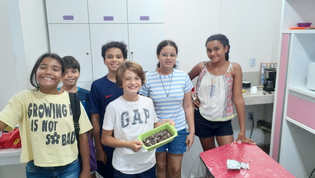 Crianças alunos Dream It em uma cooking class (aula na cozinha).