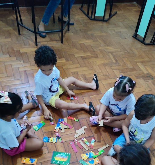 Ensinar resiliência infantil é um quebra-cabeça. Imagem de crianças solucionando um quebra-cabreça.