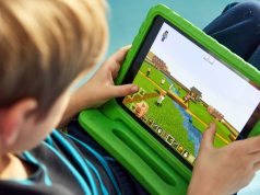 Aprender inglês com videogames: Roblox e Minecraft ajudam? Criança focada e sorridente no joguinho. É possível aprender inglês com videogames no computador.